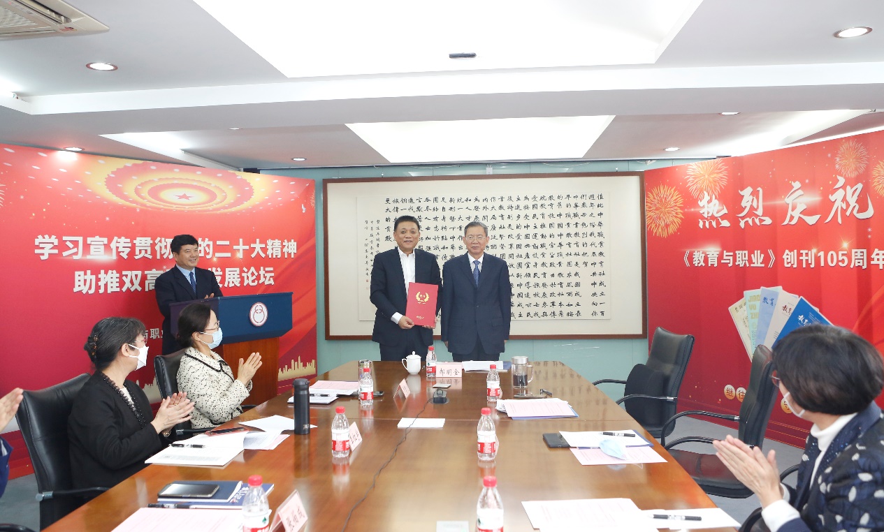 郝明金為《教育與職業(yè)》雜志編委代表陳曉明頒發(fā)聘書。中華職教社供圖