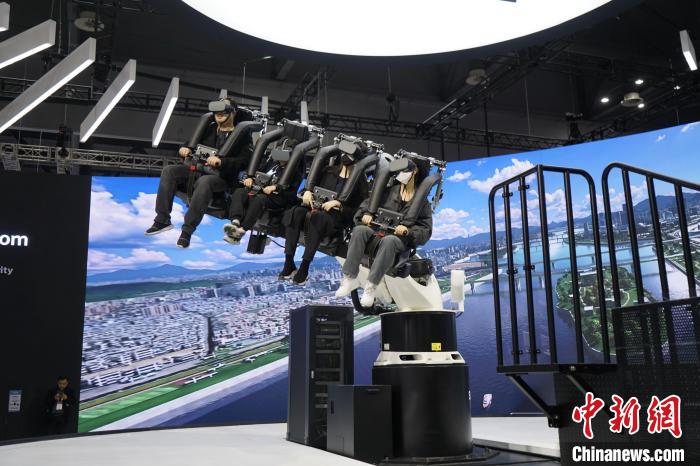 圖為觀眾在展會(huì)模擬體驗(yàn)未來(lái)城市空中移動(dòng)出行方式?！⑿?攝