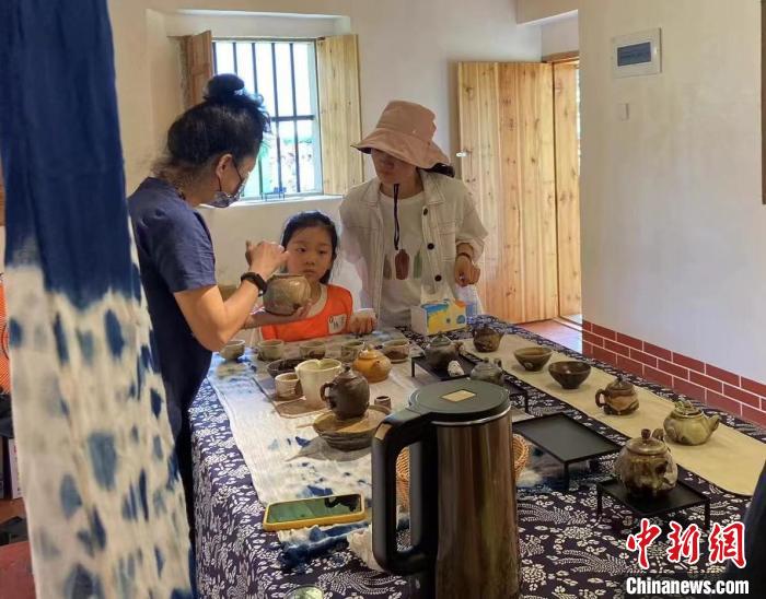 圖為：游客正在咨詢臺(tái)灣柴燒作品?！∪~秋云 攝