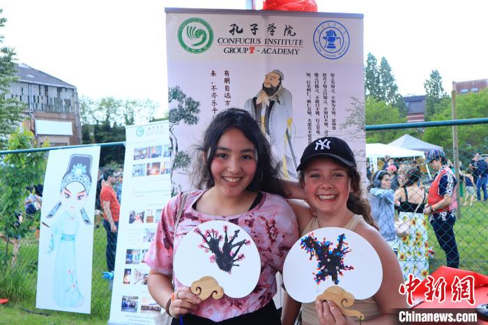 孩子們展示自己的吹墨畫團(tuán)扇作品?！◆斻肟鬃訉W(xué)院供圖