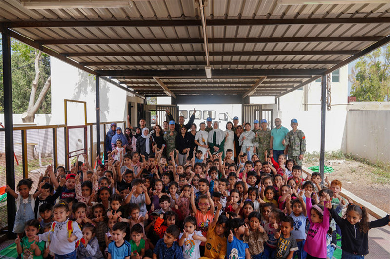 當?shù)貢r間5月30日，黎巴嫩南部庫雷拉公立小學，“六一”國際兒童節(jié)前夕，中國第21批赴黎維和多功能工兵分隊官兵看望慰問學校師生，并開展文化交流活動，圖為我維和官兵同師生合影。李竹林攝