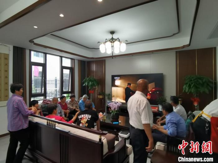 親友們集中在費(fèi)俊龍家中觀看返程的視頻?！＄娚?攝