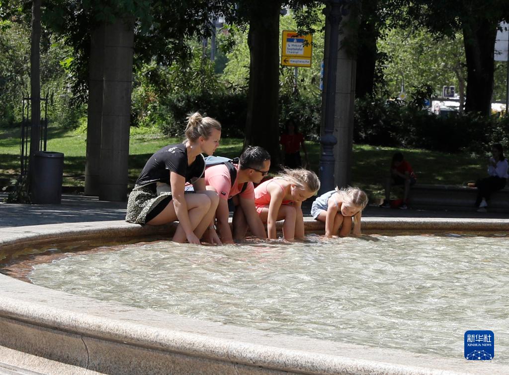 7月8日，人們在德國法蘭克福的一處噴泉玩水。近日，德國法蘭克福逐漸迎來暑熱天氣。新華社記者 張帆 攝