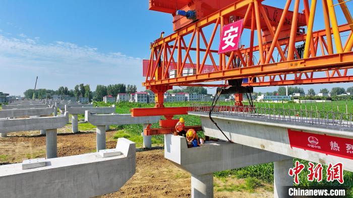 長25米重80噸的箱梁平穩(wěn)、精準(zhǔn)地落在S314分離式立交橋25號和26號墩上。　劉玉才 攝