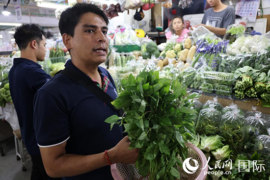 7月19日，泰國曼谷藍象餐廳員工向參加活動的多國代表介紹如何挑選新鮮蔬菜。 人民網(wǎng)記者 張矜若攝