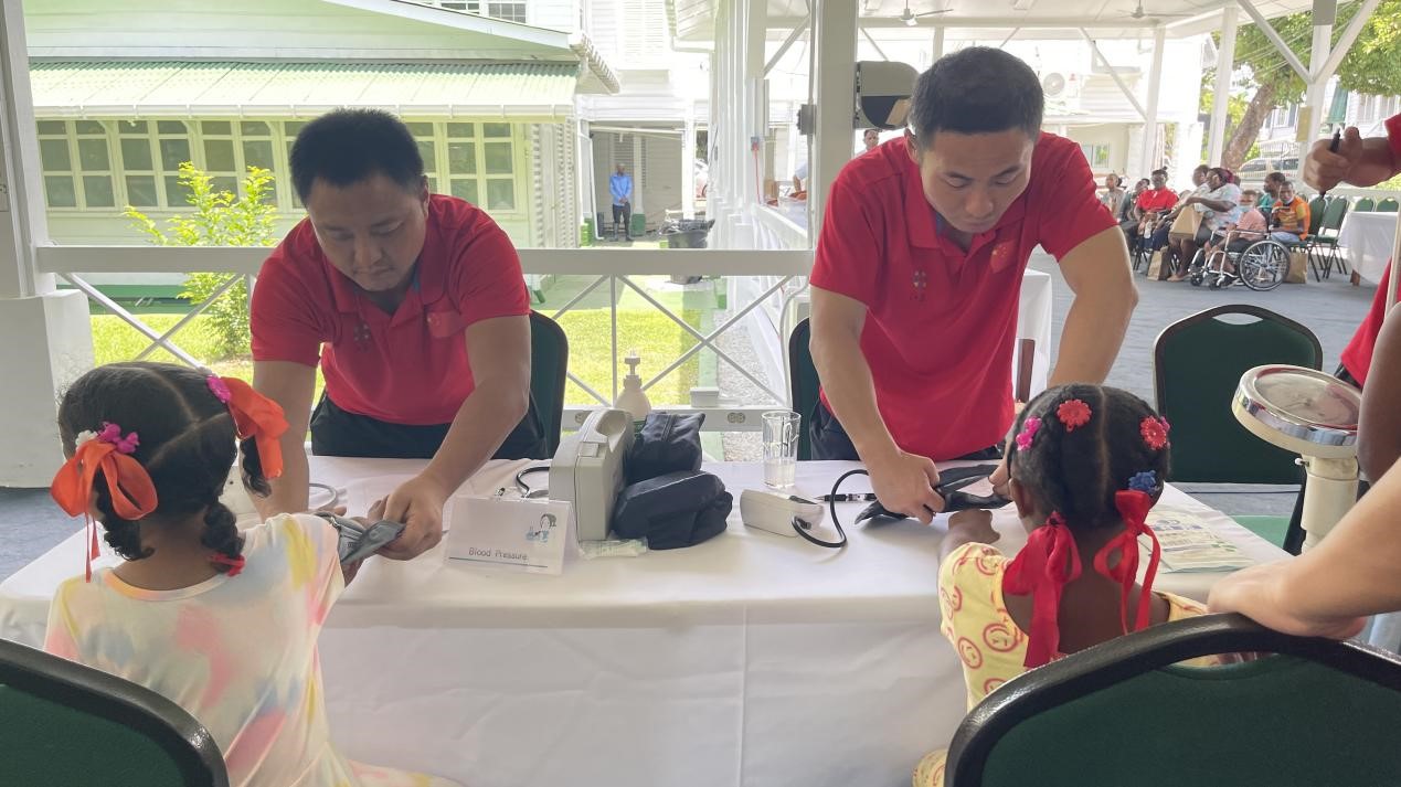 醫(yī)療隊(duì)員為福利院兒童進(jìn)行檢查。第18期援圭亞那醫(yī)療隊(duì)供圖