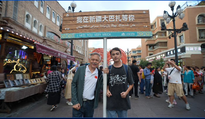 潘維廉和維吾爾族青年伊木蘭“打卡”大巴扎。主辦方供圖