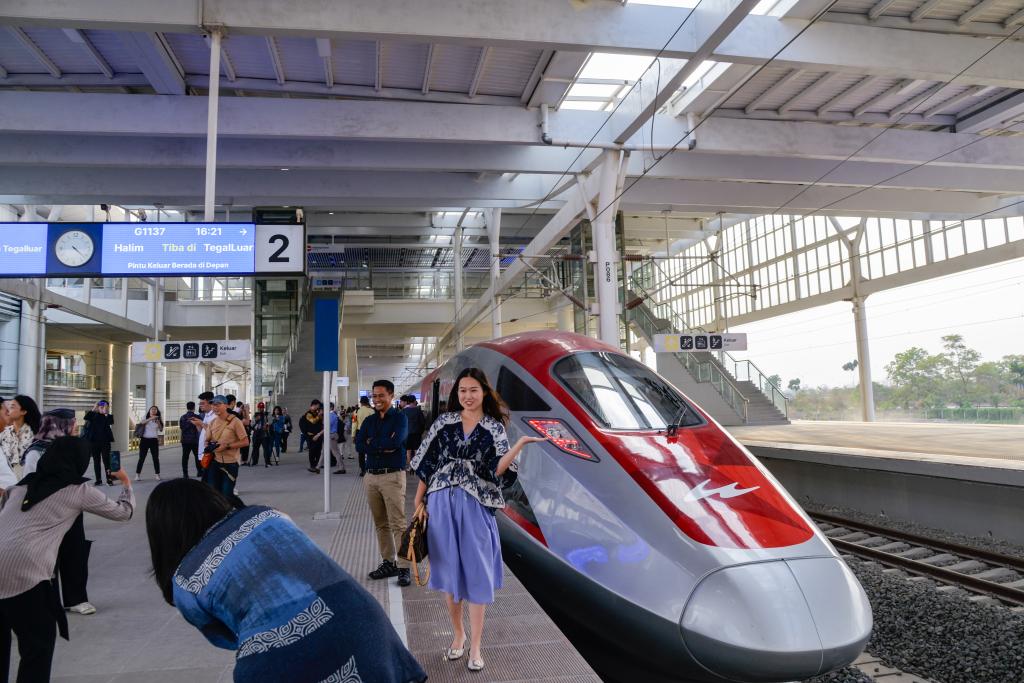 10月17日，在印度尼西亞萬隆德卡魯爾站，乘客在站臺上和雅萬高鐵高速動車組列車合影。