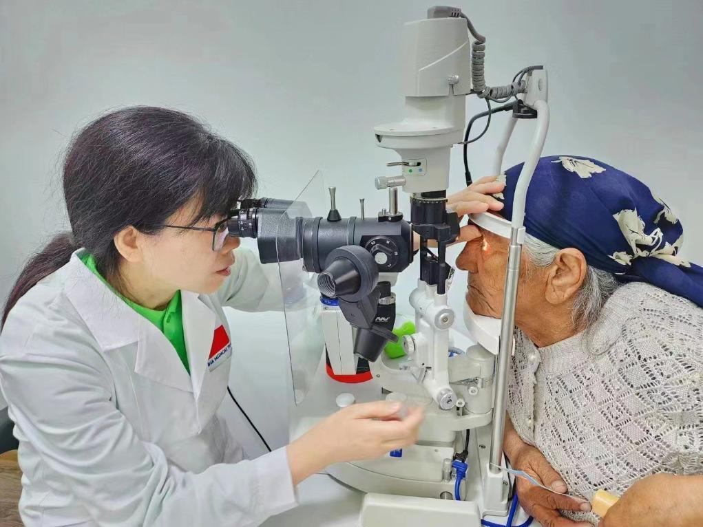 北京大學(xué)人民醫(yī)院眼科醫(yī)生鮑永珍正在為中亞白內(nèi)障患者進行眼部檢查。（北京大學(xué)人民醫(yī)院供圖）