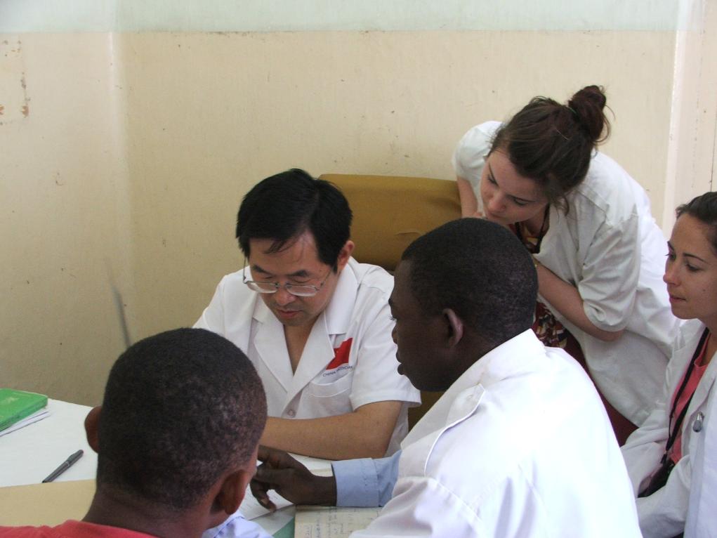 2011年7月22日，在坦桑尼亞桑給巴爾納茲莫加醫(yī)院外科門診，中國第24批援桑給巴爾醫(yī)療隊隊長盧建林為當(dāng)?shù)鼗颊咴\治并帶教實習(xí)生。新華社發(fā)（國家衛(wèi)生健康委供圖）
