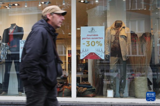   10月31日，一名男子從比利時布魯塞爾一家貼有打折信息的店鋪前走過。新華社記者 趙丁喆 攝
