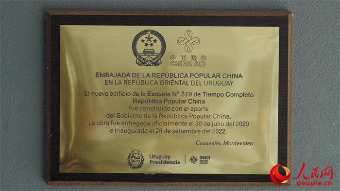 小學墻上懸掛的中國援助標識。人民網(wǎng)記者 張若涵攝