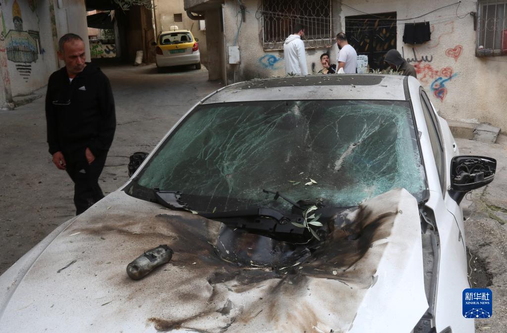 12月17日，在約旦河西岸城市圖勒凱爾姆附近的一處難民營，人們查看在沖突中損毀的車輛。新華社發(fā)（尼達(dá)爾·艾仕塔耶?dāng)z）