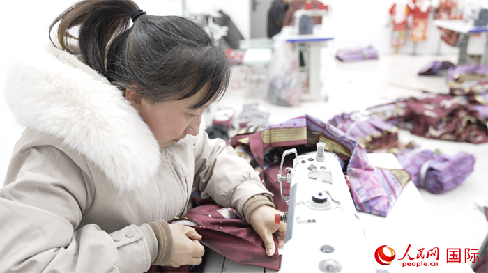 1月24日，在山東省菏澤市曹縣大集鎮(zhèn)云牧服飾有限公司，高燕正在縫制馬面裙。 人民網(wǎng)記者 袁蒙攝