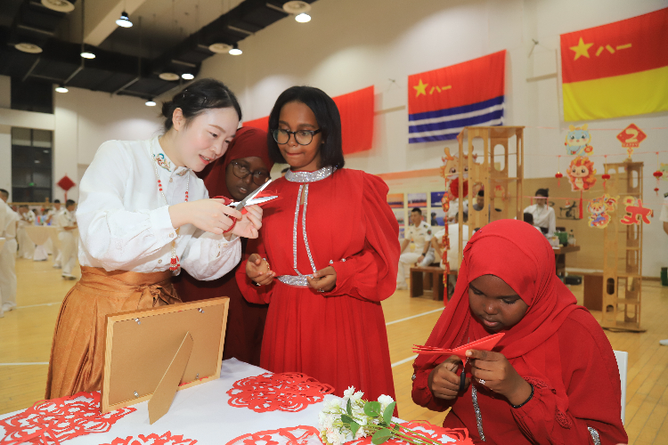 中國剪紙藝術(shù)吸引當(dāng)?shù)厝耸繀⑴c體驗(yàn)。陳錦俊攝