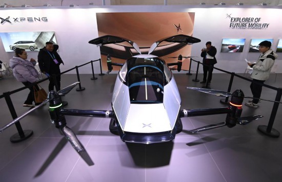 2023年12月1日，在鏈博會(huì)智能汽車鏈展區(qū)小鵬汽車展臺(tái)，參觀者觀看一臺(tái)智能飛行器。新華社記者蔡湘鑫攝