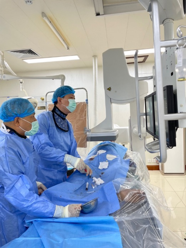 李凱教授（右）和劉海濤教授（左）為患者行TACE手術。中國駐老撾大使館供圖