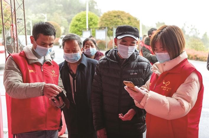 長沙縣黨員志愿者正在幫助參與核酸檢測的群眾掃描“場所碼”。劉思源 攝