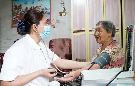 護(hù)理團(tuán)隊(duì)醫(yī)生為老人測(cè)量血壓。 陳佳兵攝