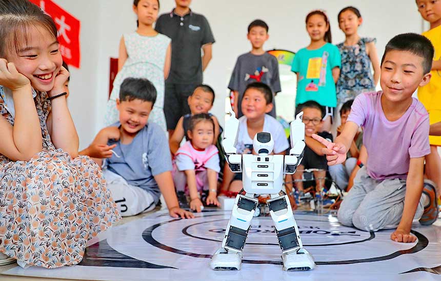 2022年7月19日，河北省秦皇島市海港區(qū)白塔嶺街道秦皇半島第二社區(qū)內(nèi)，小朋友正在觀看“機(jī)器人跳舞”。 曹建雄攝