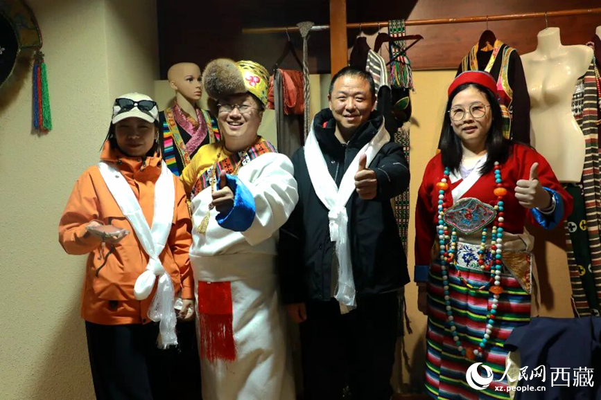 游客在扎西曲登社區(qū)體驗藏族服飾文化。大家身著色彩鮮艷的藏裝，佩戴特色飾品，臉上洋溢著喜悅的笑容。人民網(wǎng)記者 吳雨仁攝