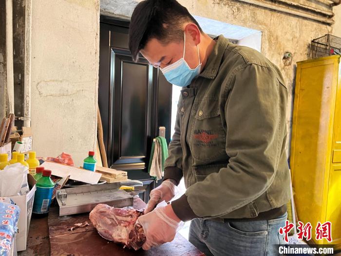 圖為雪豹“奶爸”史壽軍正在準(zhǔn)備投喂雪豹的食材?！●R銘言 攝