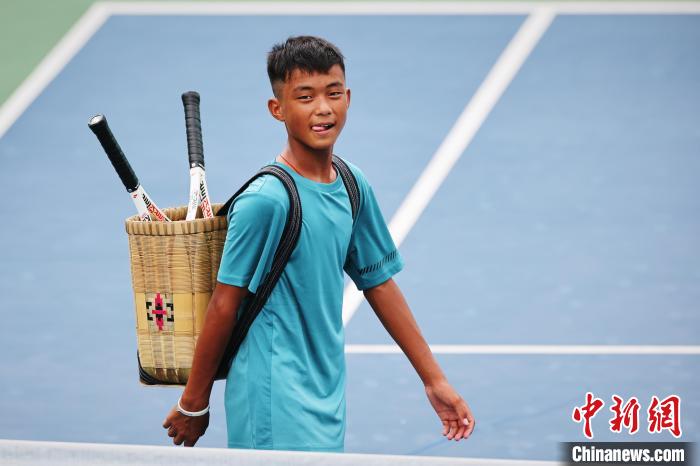 王發(fā)背著背簍在賽場上。　李建藝 攝