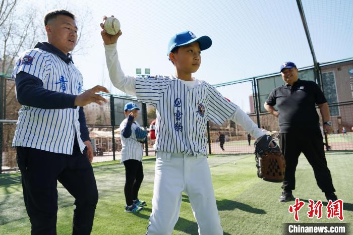 圖為教練指導(dǎo)小棒球手?jǐn)S球技術(shù)?！●R銘言 攝