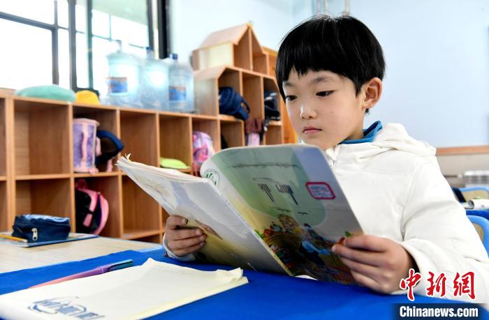 3月14日，西藏拉薩市第一小學(xué)一年級六班學(xué)生丁增樂吉在閱讀藏語課本?！±盍?攝