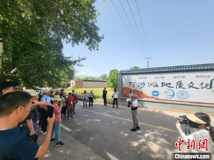 圖為中國地質(zhì)大學(北京)教授張緒教介紹村落情況?！『衍?攝