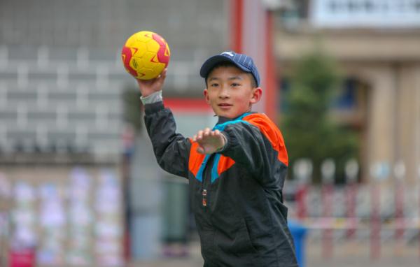 在高原上教孩子們打手球，“慢慢兒來(lái)，甭著急！”