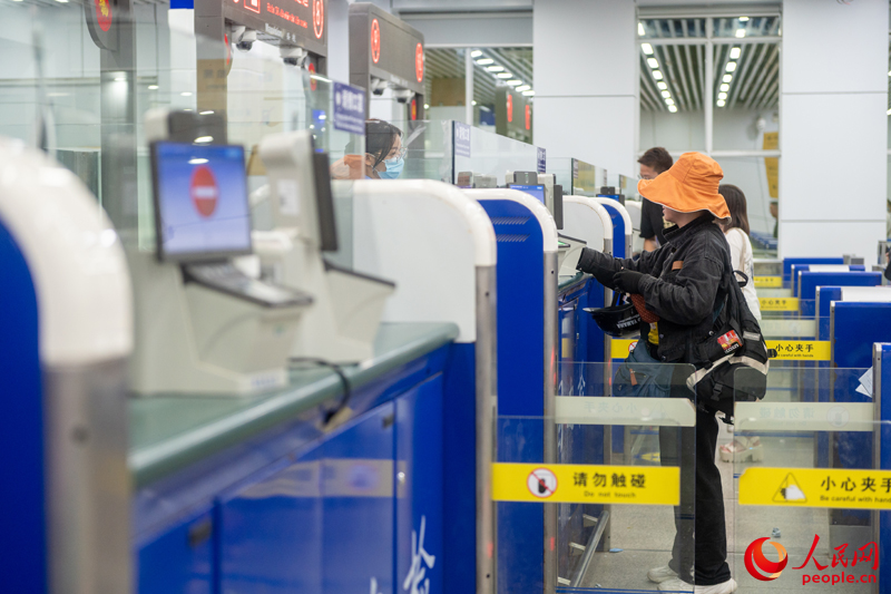 越南游客正在辦理入境手續(xù)。人民網(wǎng)記者 嚴(yán)立政攝