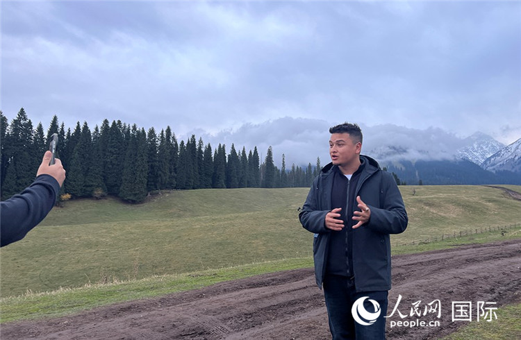 在庫爾德寧，吾買爾江被雪山美景震撼，即興錄制了短視頻作品。人民網(wǎng)記者曾書柔攝