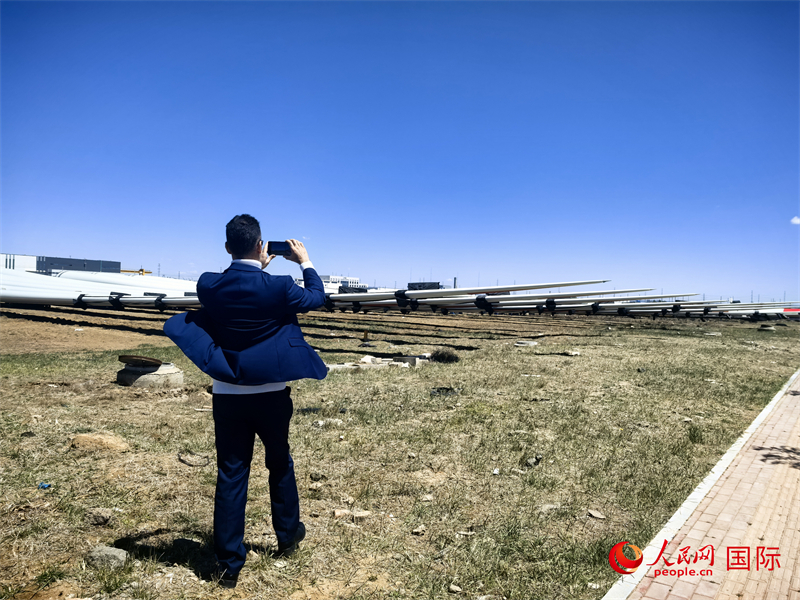 外媒記者拍攝廠房外的風(fēng)力渦輪發(fā)電機(jī)的巨型漿葉。人民網(wǎng) 楊春燕攝