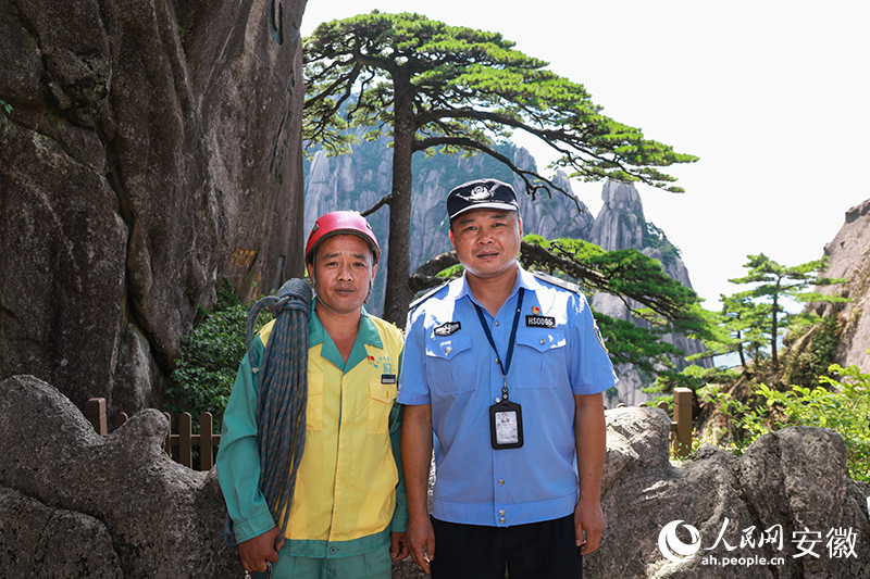 全國(guó)道德模范李培生（左）和胡曉春在迎客松前合影。人民網(wǎng)記者 張俊攝