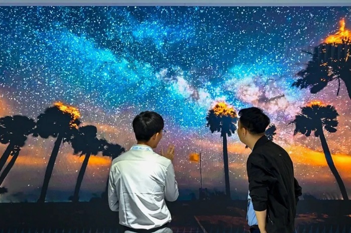 長(zhǎng)春光博會(huì)希達(dá)電子展區(qū)，一位工作人員正在給一位觀眾講解。（長(zhǎng)春新區(qū)供圖）