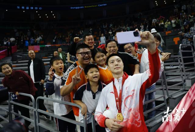 11月12日，十五運(yùn)會(huì)男籃成年組決賽，廣東隊(duì)獲得冠軍后，胡明軒與球迷們合影留念。張由瓊 攝