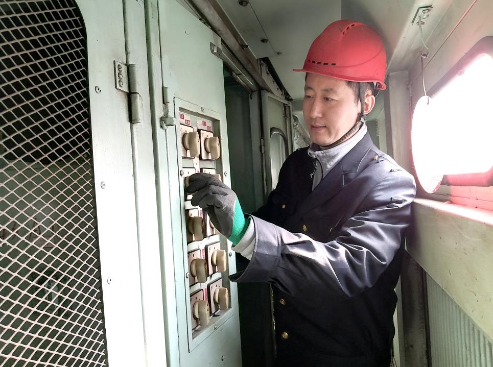 韓文盛認(rèn)真檢查低壓柜。