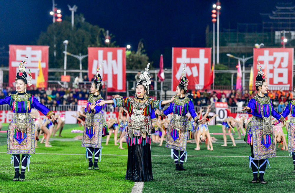 2025年3月14日，2025年貴州“村超”40強交叉賽在榕江“村超”足球場舉行，演員在比賽間隙表演侗族大歌，民族文化伴隨著體育賽事成功“出圈”。圖片來源：新華社