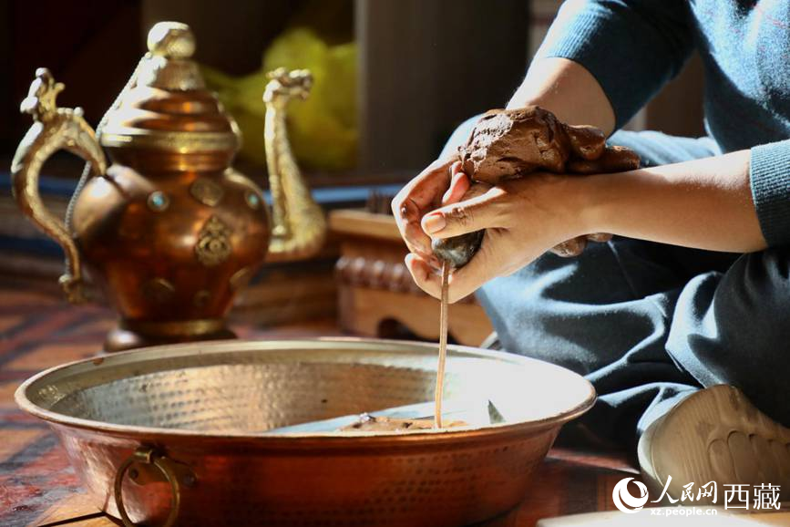 牛角鉆孔，將木泥擠出。人民網(wǎng)記者 次仁羅布攝