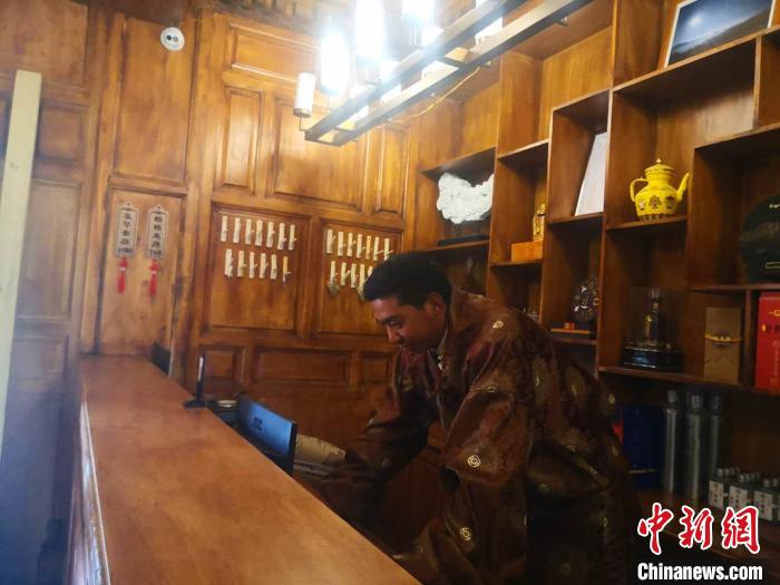 圖為桑杰才讓用電腦處理財(cái)務(wù)?！∈缝o靜 攝