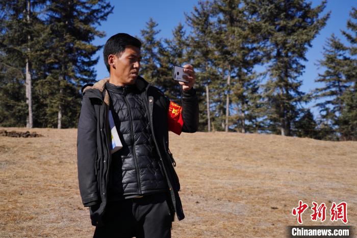 圖為桑杰加進行巡查并拍照記錄。　馬銘言 攝