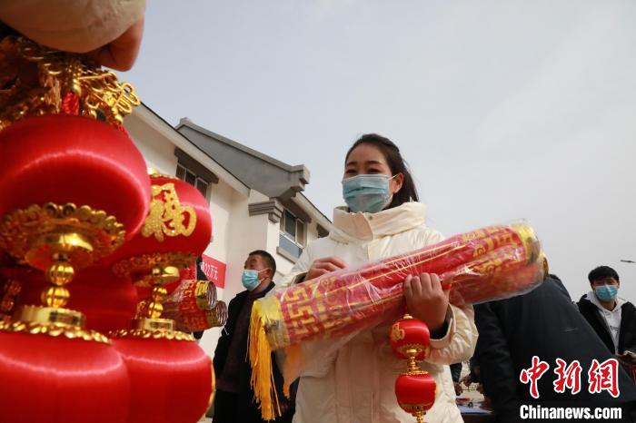 27日，蘭州新區(qū)為舟曲避險搬遷移民送“春節(jié)包”，楊周馬草前往領(lǐng)取，紅色寓意來年的日子紅紅火火。　魏建軍 攝