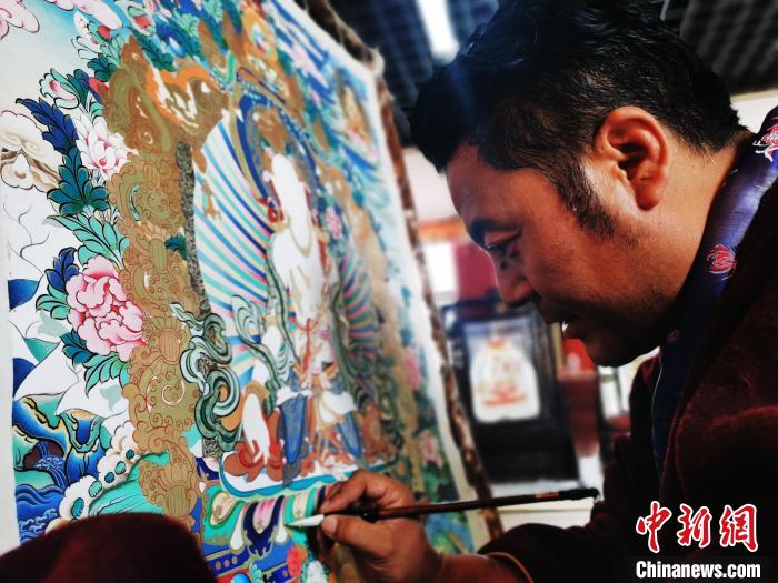 圖為久美尖措創(chuàng)作唐卡?！?zhí)砀?攝