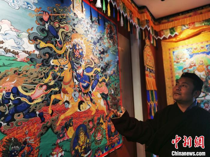 圖為久美尖措展示唐卡作品。　張?zhí)砀?攝