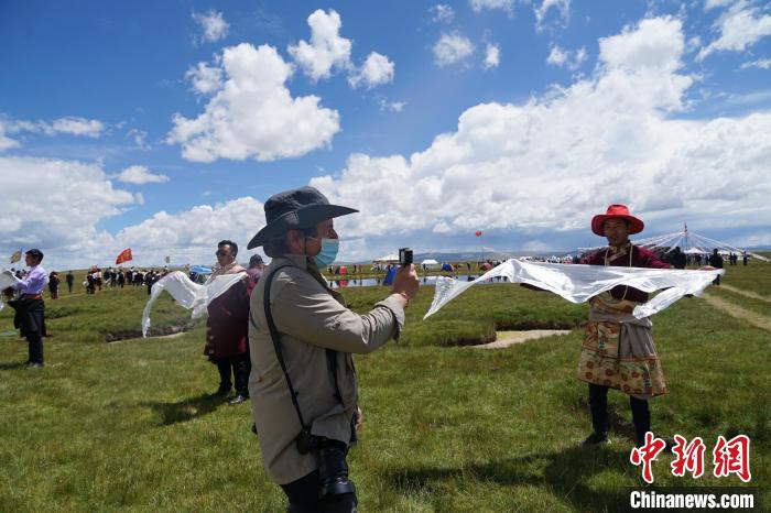 圖為一名外籍攝影師記錄當?shù)夭刈鍤g迎儀式?！●R銘言 攝