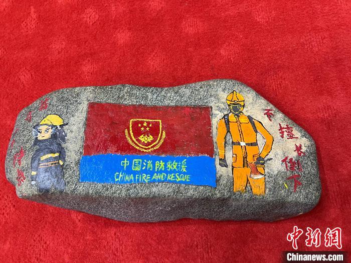 圖為玉樹消防指戰(zhàn)員創(chuàng)作的石頭畫作品《我有一個(gè)特點(diǎn)“不擅長倒下”》?！O瑞祥 攝