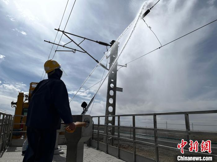 圖為高壓水槍的水柱沖洗絕緣子串?！「邌⒑?攝
