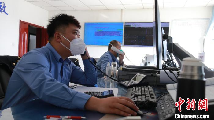 圖為貨運調(diào)度人員與外勤工作人員聯(lián)系掌握車輛裝載情況?！±钌?攝