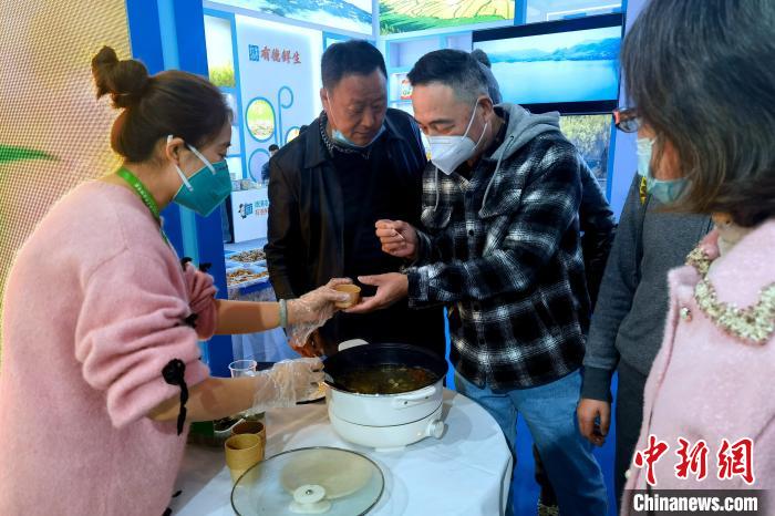 圖為杭州市民品嘗茶卡羊肉?！±铍h 攝